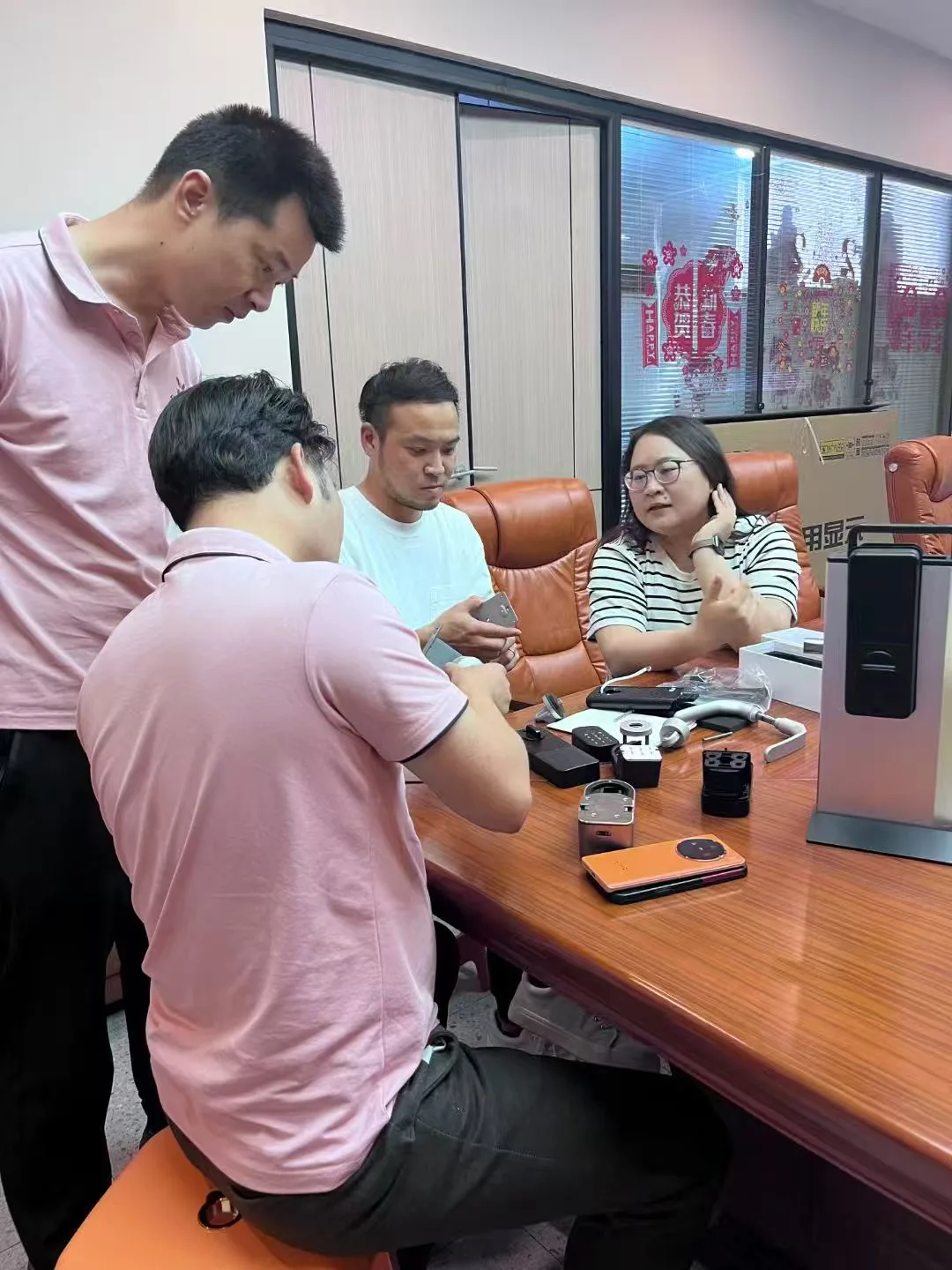 Clientes japoneses examinam componentes de fechadura remota invisível na sala de reuniões da WAFU